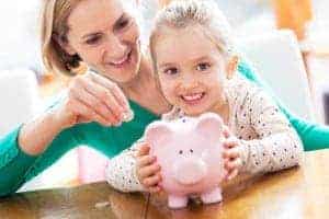 Mother and daughter saving money for a Gatlinburg vacation in a pink piggy bank