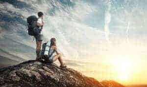 Two backpackers standing at the top of a mountain in the Smokies looking at the view