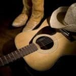 Guitar, boots and cowboy hat represent country music