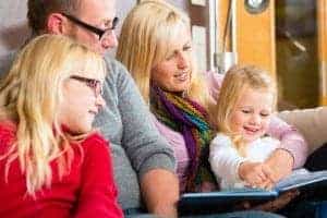 Family sitting together to read one of the books from Dolly Parton's Imagination Library