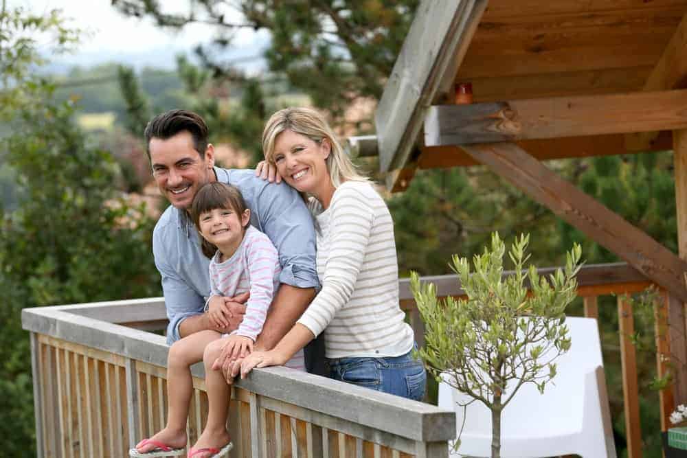 Family standing on the porch of a Gatlinburg cabin rental