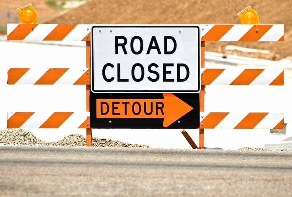 Road closed and detour sign at a construction site