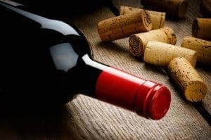 Wine bottle next to corks on a table
