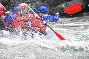 White water rafters on the river being splashed