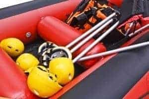 Yellow white water rafting helmets and oars in a raft