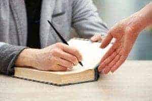 Author signing a book for a fan.