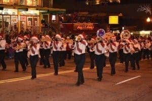 A marching band with Santa hats performing at the Fantasy of Lights Christmas Parade in Gatlinburg.