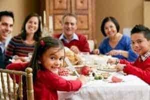 Happy multi-generational family preparing to eat Christmas dinner.