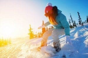 A woman snowboarding down a snowy slope.