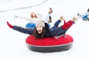 A young woman smiling while snow tubing at Ober Gatlinburg