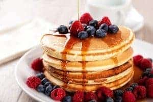 A plate of pancakes in Gatlinburg covered in syrup and berries.