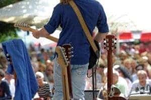 Outdoor concert with guitarist on stage.