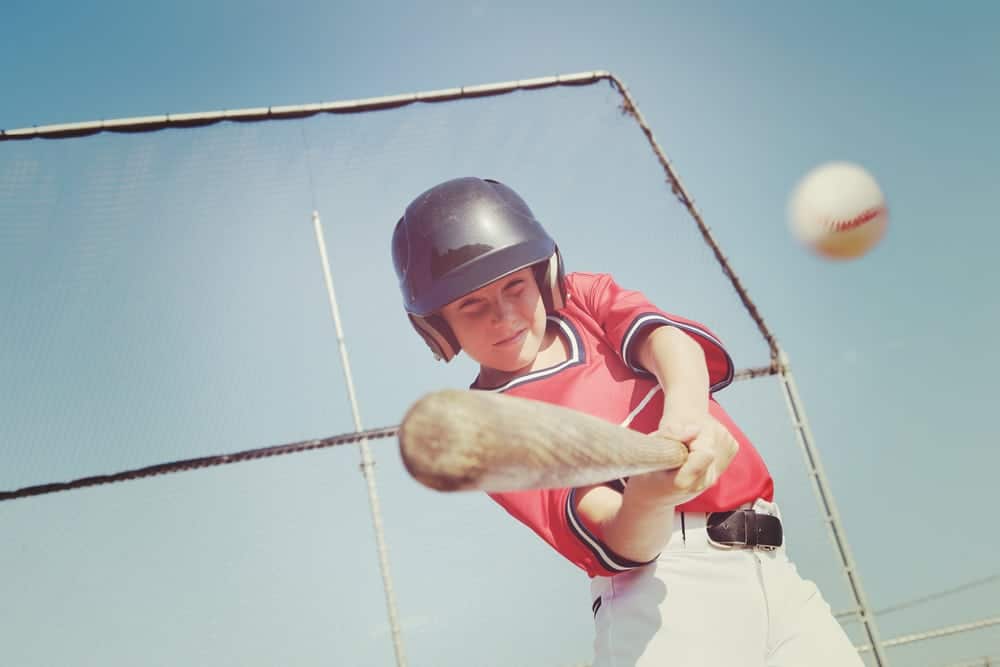 A young baseball player hitting a ball at The Ripken Experience Pigeon Forge.