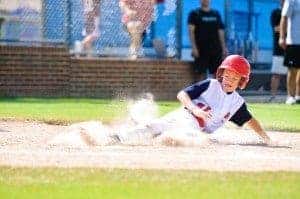 A young baseball player sliding into home plate.