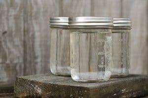 Three mason jars filled with clear moonshine.