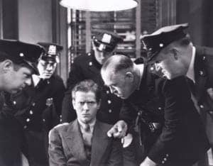 A man being interrogated by the police in the 1930s.