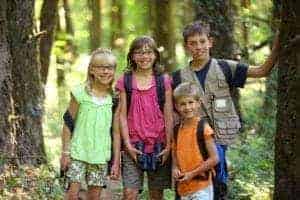 Kids standing by trees in the woods