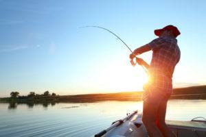 Man fishing at sunset on the lake