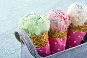 Three ice cream cones in a metal basket.