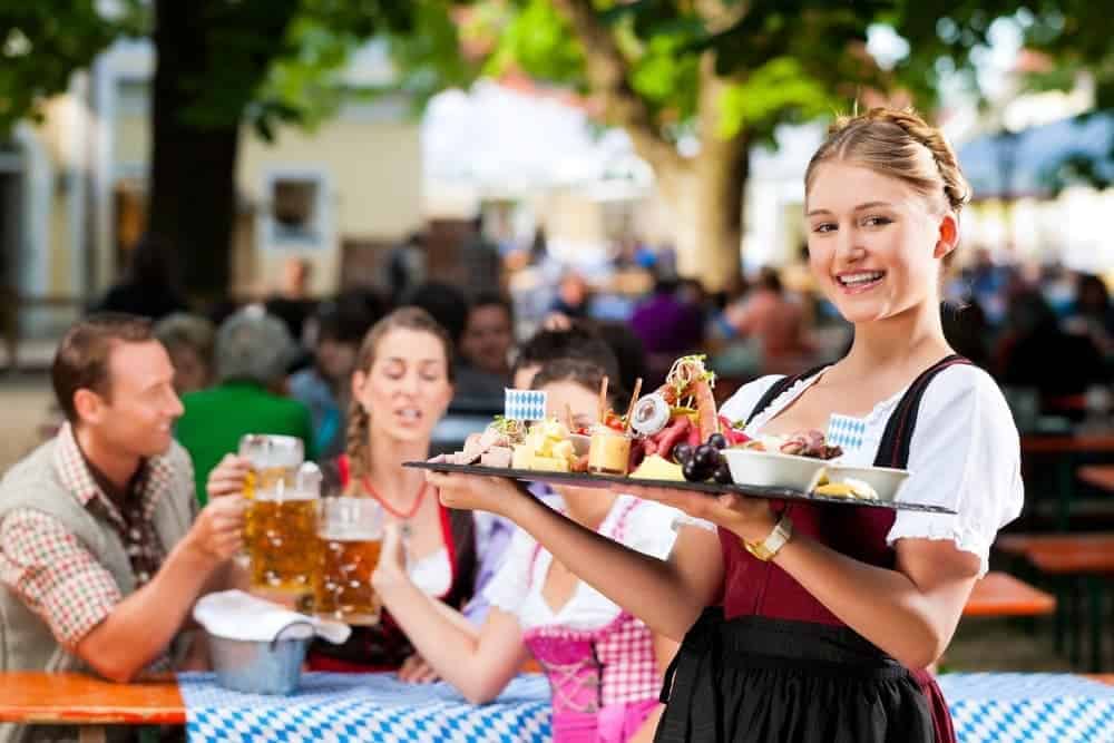 A waitress in traditional Bavarian clothing at an Oktoberfest celebration.