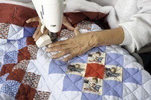 A woman making a quilt.