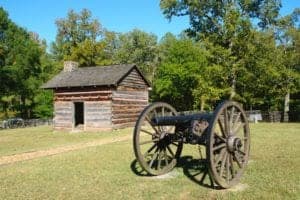 An historic cabin and cannon.