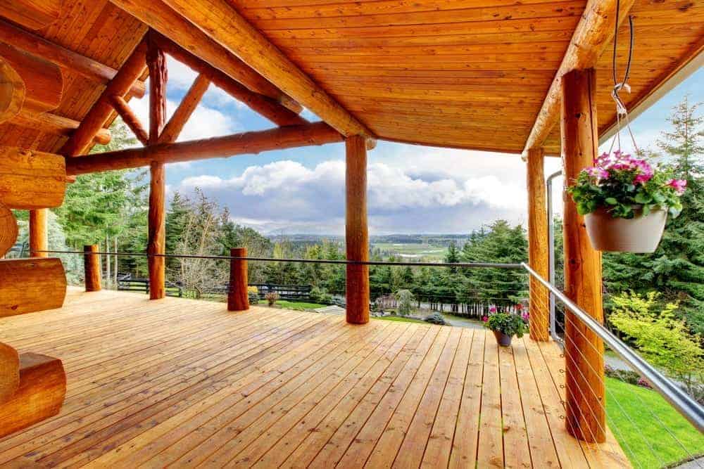 The covered porch of a beautiful log cabin.