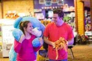 A young couple with tickets and a stuffed bear at Bear Country Fun Park in Pigeon Forge.