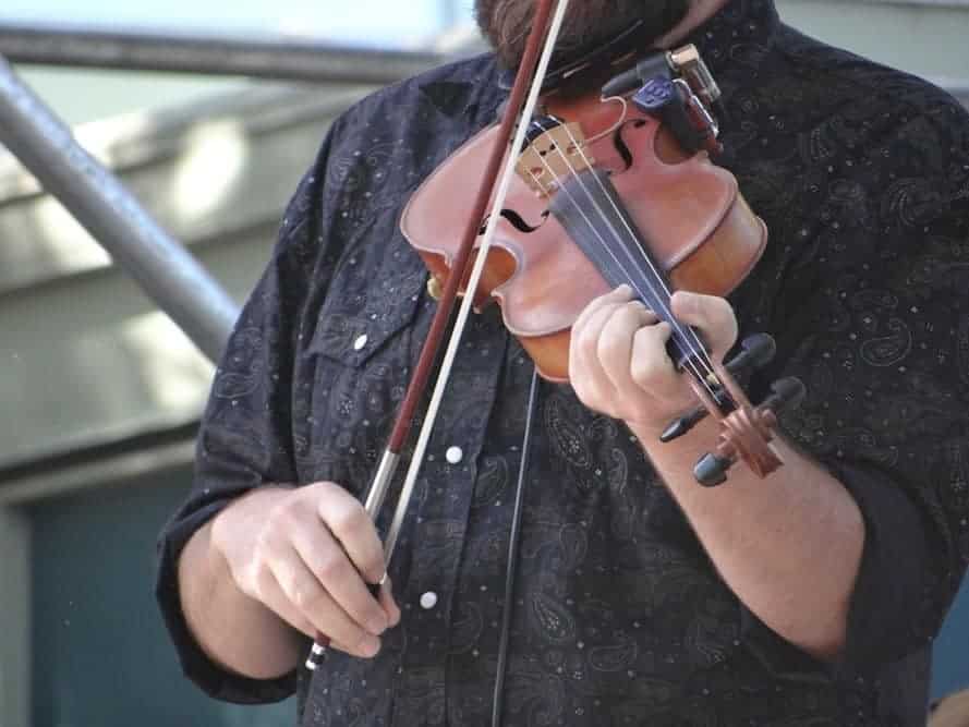 A man playing a fiddle on stage.