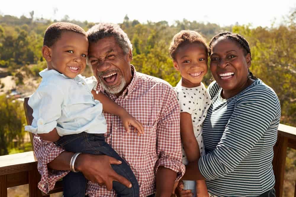 Grandparents and grandchildren on a deck with scenic views.