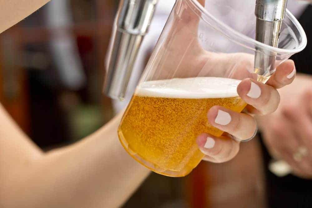 Beer being poured into a cup at a beer festival.