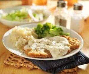 Country fried steak with gravy and sides.