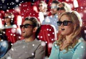 Young people wearing 3D glasses in a theater.