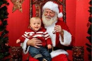 A happy child sitting on Santa's lap.