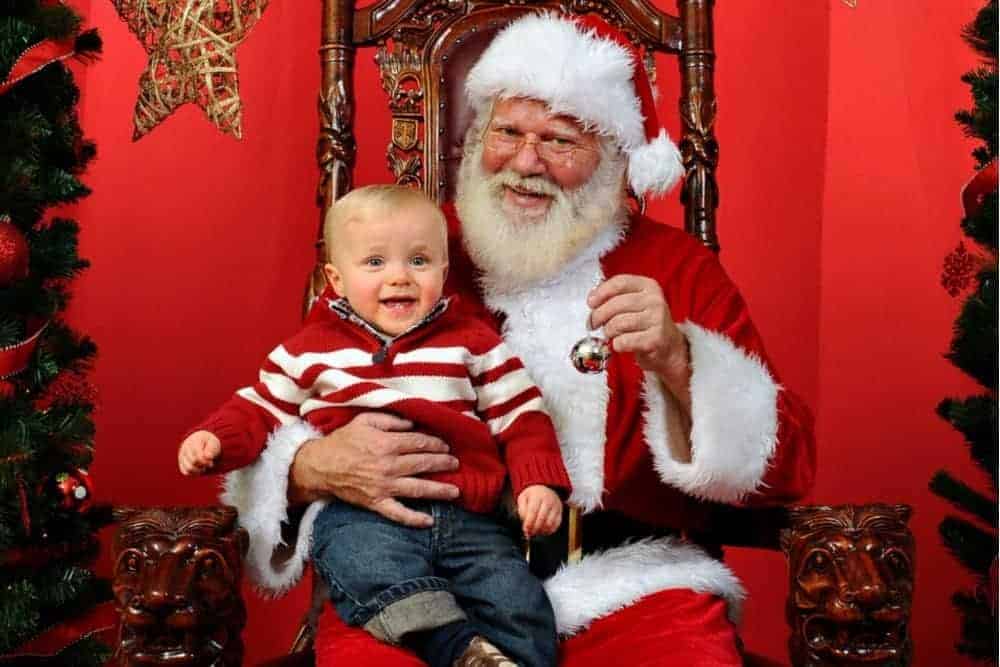 A happy child sitting on Santa's lap.