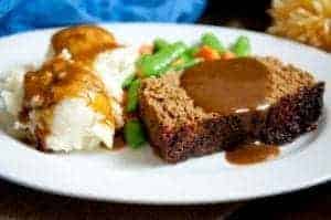 A plate of meatloaf with side dishes.