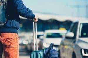 Man with luggage waiting to be picked up at the airport.