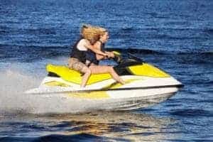 A couple riding a jet ski on a lake.