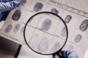 detective looking at fingerprint samples