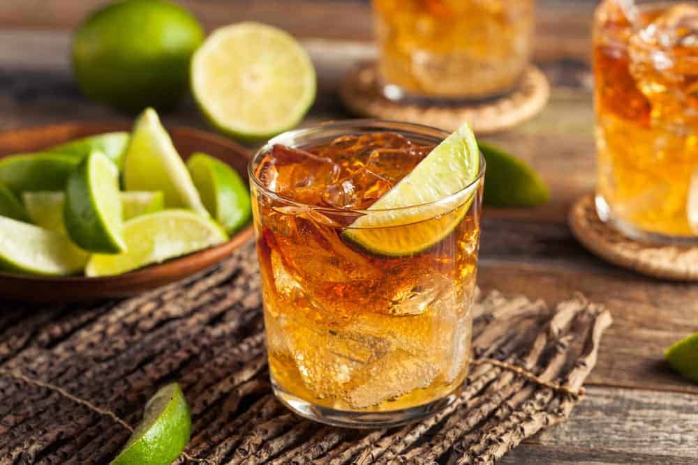 A Dark and Stormy rum cocktail with limes.