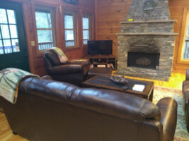 Spacious living/den area with stone fireplace