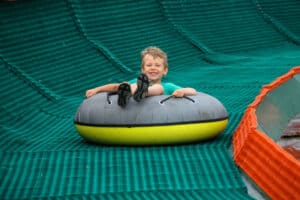 boy tubing down a hill