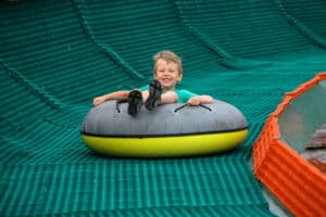 boy tubing down a hill