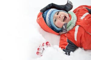 happy boy laying in the snow