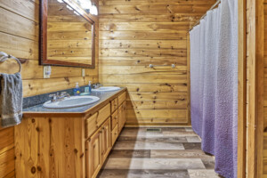 Lower level ensuite bathroom with double sink and tub