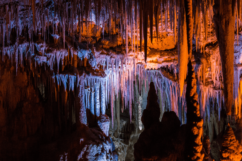 stalagmites in cave with colorful lights