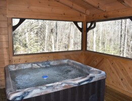 Private hot tub located in enclosed deck overlooking wooded setting