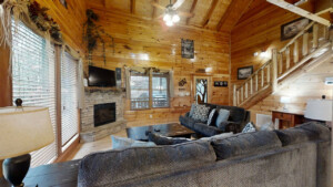 High ceiling cabin with 2 couches electric fire place, stairway to game room