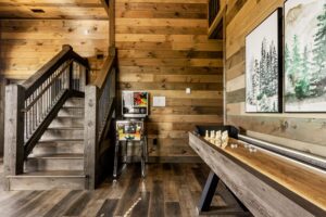 The downstairs game room with a shuffle board/bowling table and pinball game.